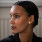 Elegant and stylish woman wearing Round Diamond Studs, made of sustainable lab-grown diamonds and 18k solid gold.