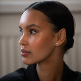 Elegant and stylish woman wearing Round Diamond Studs, made of sustainable lab-grown diamonds and 18k solid gold.