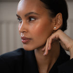 Elegant woman wearing Diamond Studs, made of round-cut lab-grown diamonds and 18k solid gold.