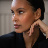 Elegant woman wearing Diamond Studs, made of round-cut lab-grown diamonds and 18k solid gold.