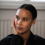 Elegant and stylish woman wearing Round Diamond Studs, made of sustainable lab-grown diamonds and 18k solid gold.