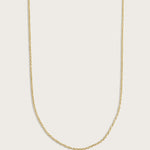 Simple gold chain necklace displayed on a light beige background.