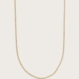 Simple gold chain necklace displayed on a light beige background.