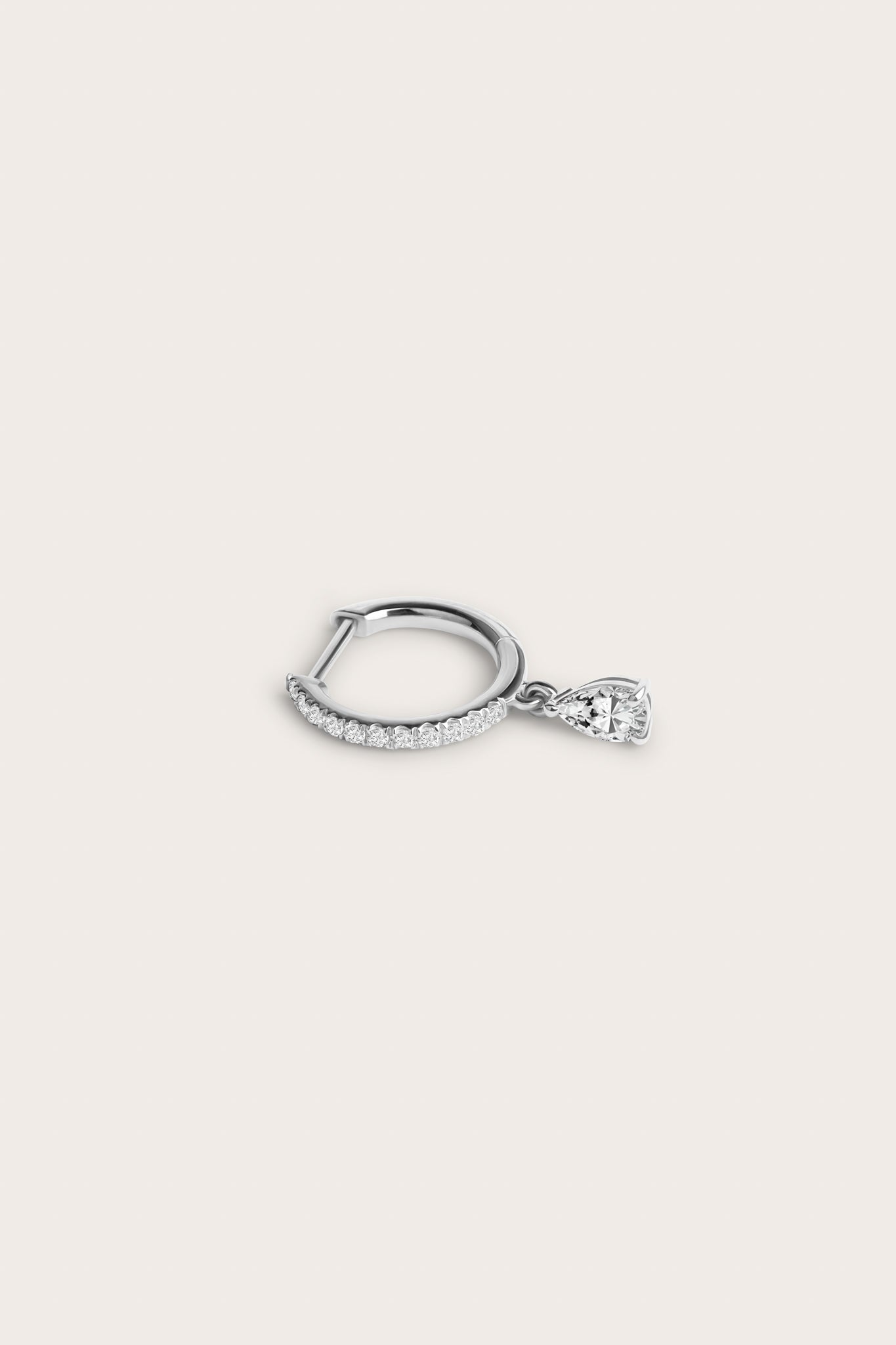 Silver hoop earring adorned with pavé-set diamonds and a dangling pear-shaped diamond, displayed on a light beige background.