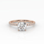 Classic cushion shaped solitaire diamond ring with a rose gold band featuring pavé diamonds.