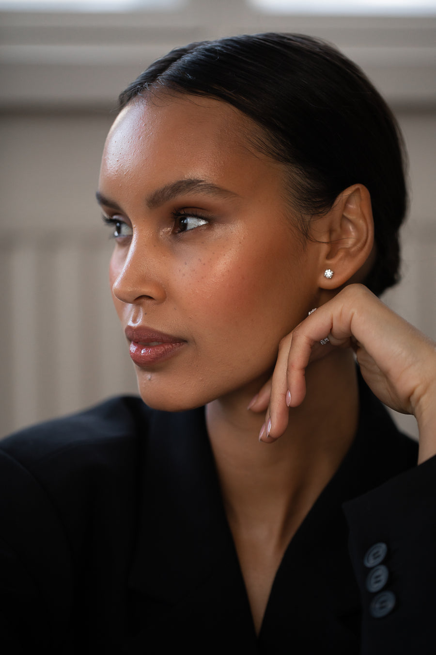 Elegant woman wearing Diamond Studs, made of round-cut lab-grown diamonds and 18k solid gold. 