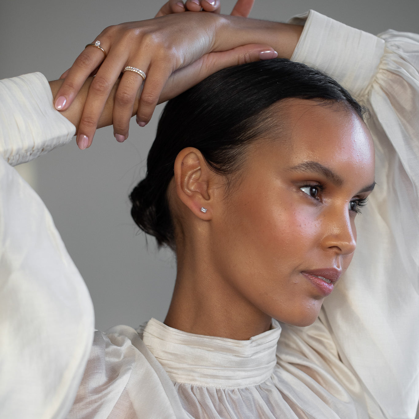 Elegant woman wearing Diamond Studs, made of emerald-cut lab-grown diamonds and 18k solid gold. 
