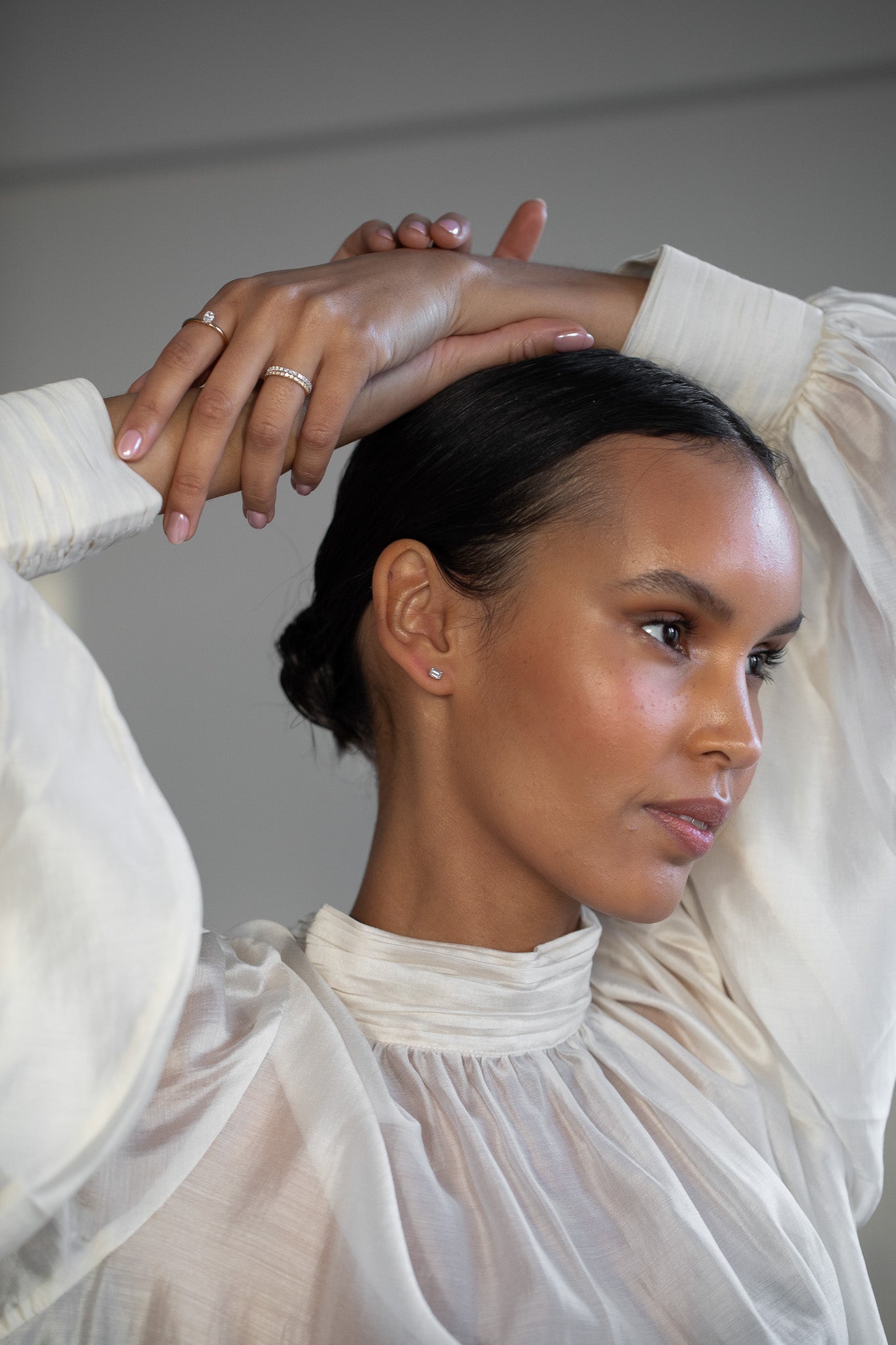 Elegant woman wearing Diamond Studs, made of emerald-cut lab-grown diamonds and 18k solid gold. 