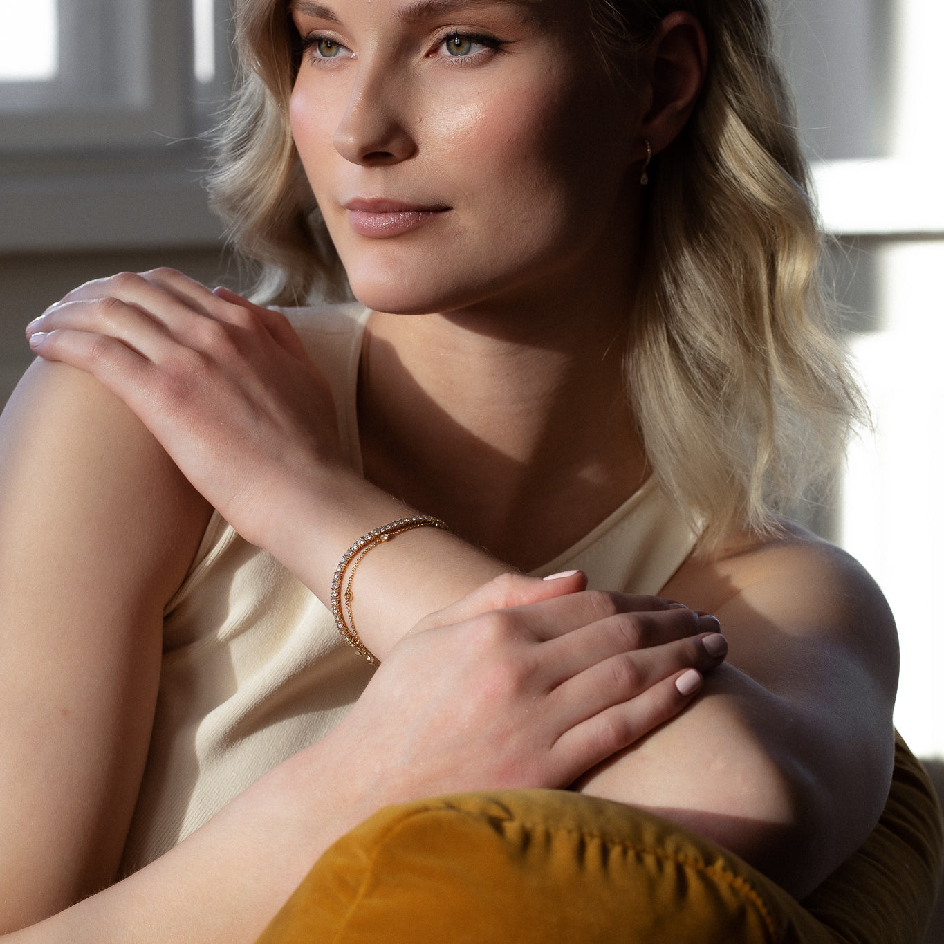 Elegant woman wearing sustainable Diamond Station Bracelet that is made of ethical lab-grown diamonds and recycled solid gold. 