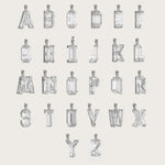 Collection of silver alphabet pendants, each adorned with sparkling gemstones, displayed on a light beige background.