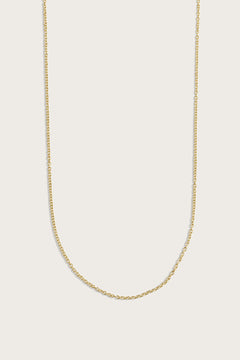 Simple gold chain necklace displayed on a light beige background.
