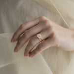 A KARAAT Emerald Trilogy diamond engagement ring in 18k white gold styled with a delicate organza dress.