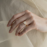 A KARAAT Emerald Trilogy diamond engagement ring in 18k rose gold styled with a delicate organza dress.
