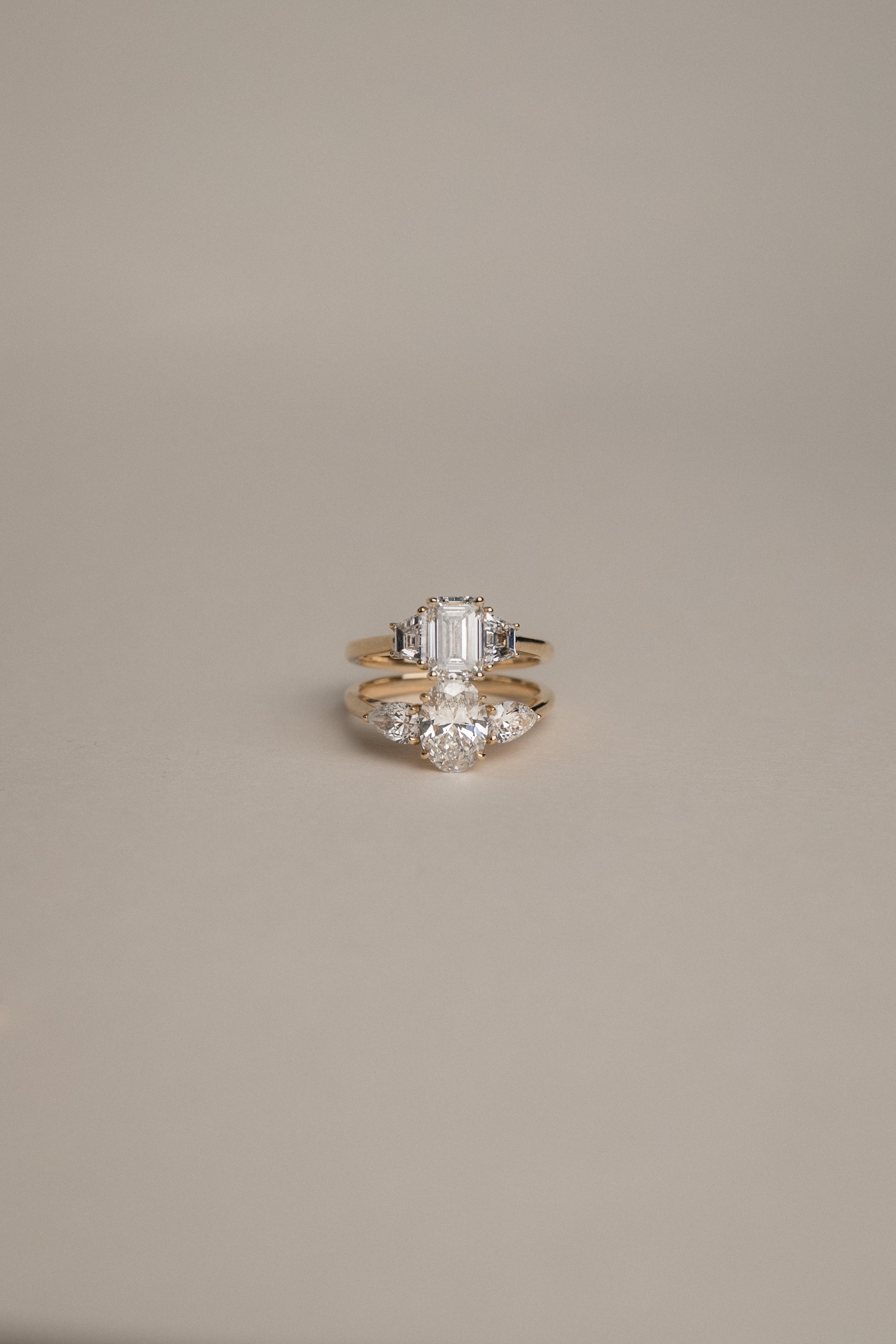 Product focus on the KARAAT Emerald Trilogy in 18k yellow gold, showcasing the clear step-cut lab-grown diamonds.