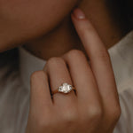 Detailed view of the KARAAT Emerald Trilogy in 18k white gold on a model's hand, highlighting the elongating emerald cut.