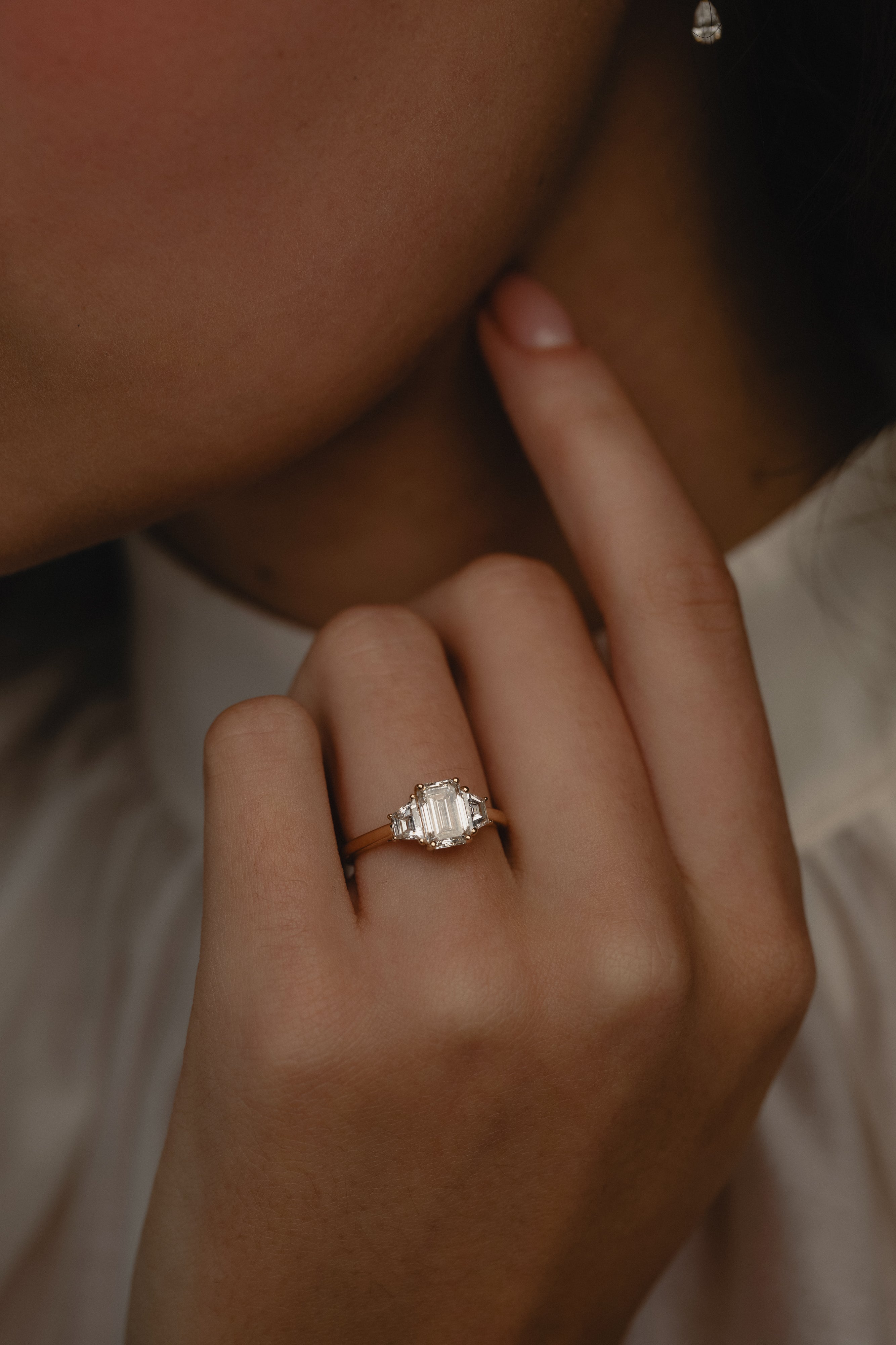 Detailed view of the KARAAT Emerald Trilogy in 18k white gold on a model's hand, highlighting the elongating emerald cut.