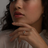 A KARAAT Emerald Trilogy ring in 18k yellow gold worn by a model, providing contemporary bridal inspiration.