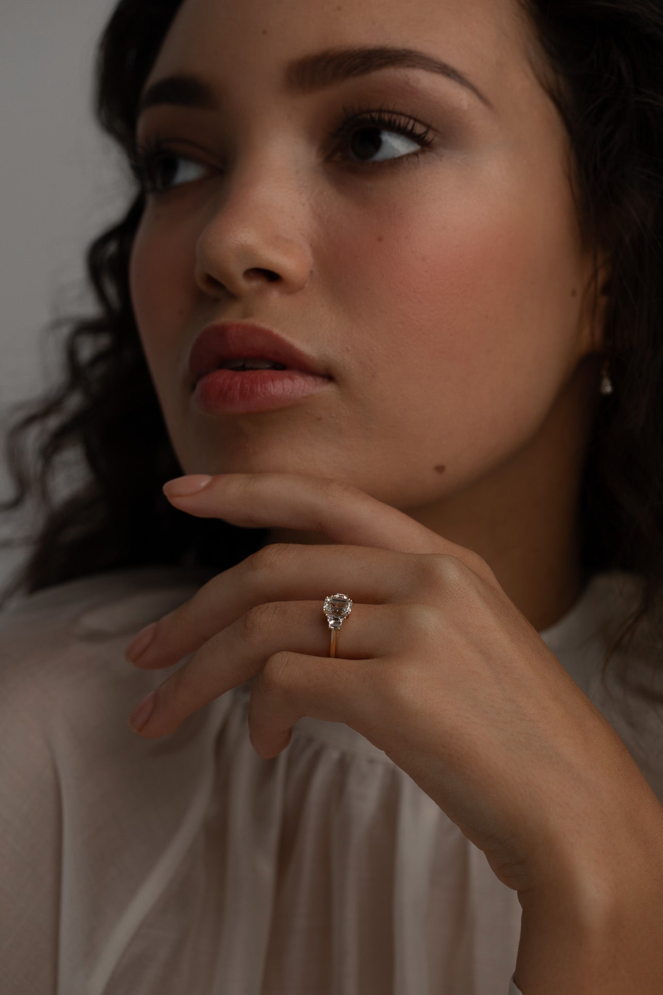 A KARAAT Emerald Trilogy ring in 18k white gold worn by a model, providing contemporary bridal inspiration.