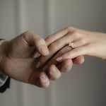 Couple holding hands, the woman wearing the KARAAT Marquise Trilogy lab-grown diamond engagement ring in yellow gold