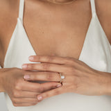 A model wearing the KARAAT Oval Six Prong Solitaire in 18k rose gold, stacked with Marquise Half Eternity diamond wedding band.