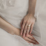 Bride wearing KARAAT Oval Solitaire diamond engagement ring in 18k white gold paired with a tulle wedding dress.