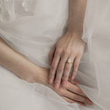 Bride wearing KARAAT Oval Solitaire diamond engagement ring in 18k white gold paired with a tulle wedding dress.