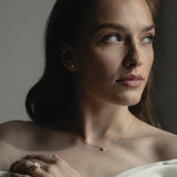 Elegant bridal jewelry by KARAAT featuring a lab-grown diamond engagement ring Oval Solitaire in 18k yellow gold and matching wedding band, styled for a modern wedding look.