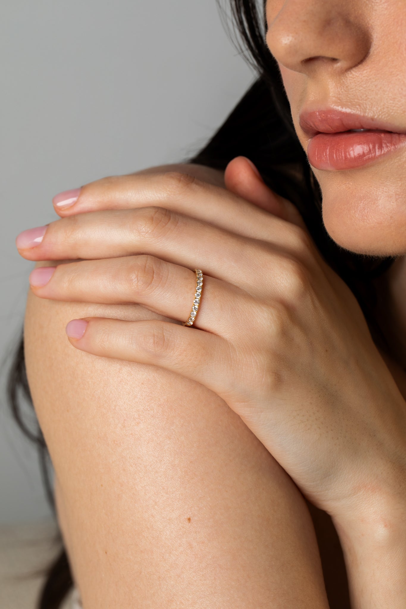 Close-up lifestyle shot of a model resting her hand on her shoulder, displaying the Pavé Diamond Ring II crafted in 18k white gold.