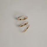 A clean flat-lay product shot displaying three KARAAT pavé diamond rings on a light grey background, showcasing different band widths and diamond carat sizes in polished rose gold.