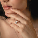 Model wearing the KARAAT Round and Pear Toi et Moi diamond ring in yellow gold, hand raised to her lips