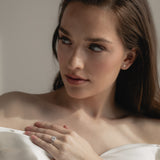 A bride wearing the KARAAT Round Six Prong Solitaire ring in 18k yellow gold, styled with a modern wedding look.