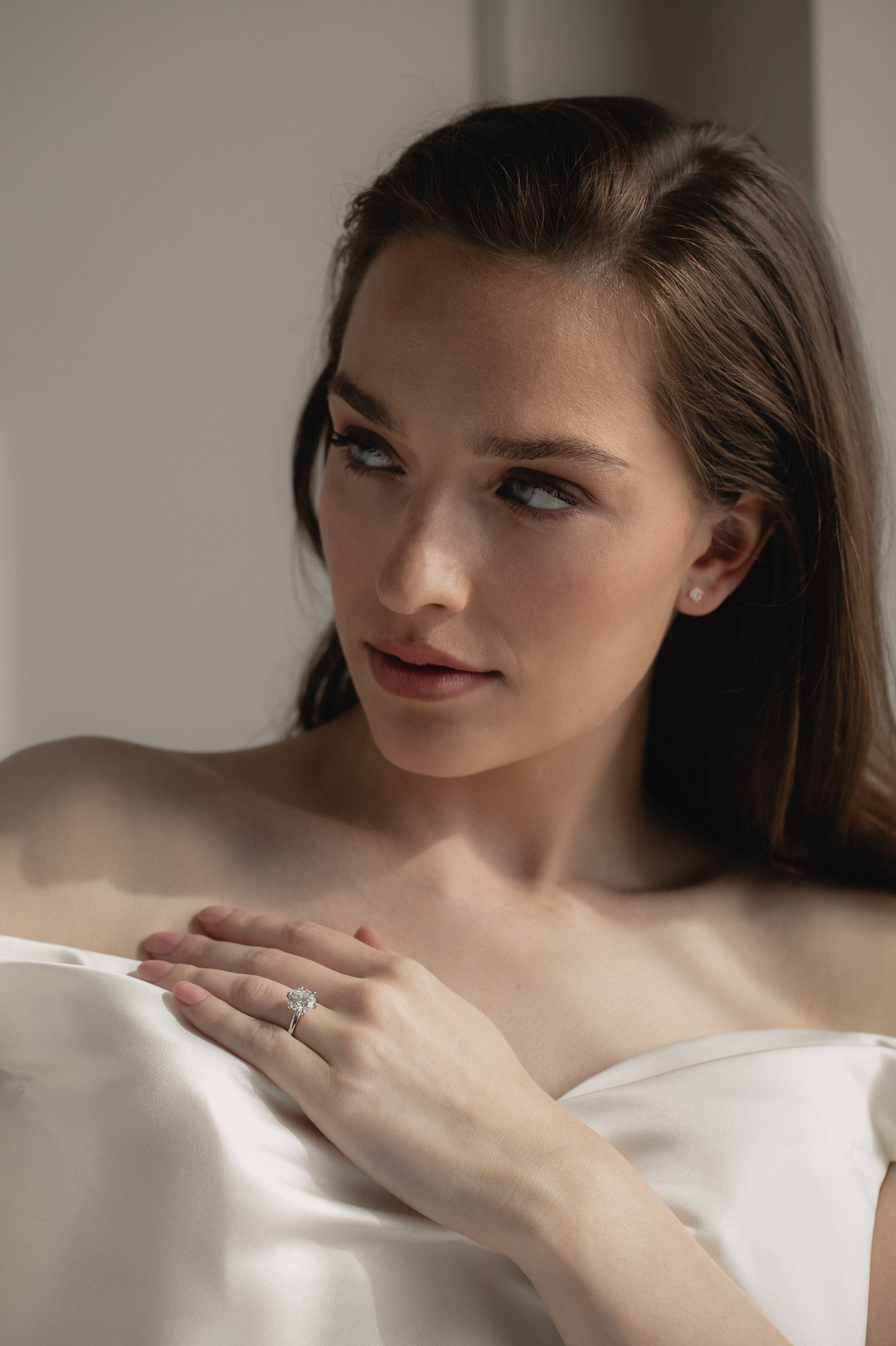 A bride wearing the KARAAT Round Six Prong Solitaire ring in 18k white gold, styled with a modern wedding look.