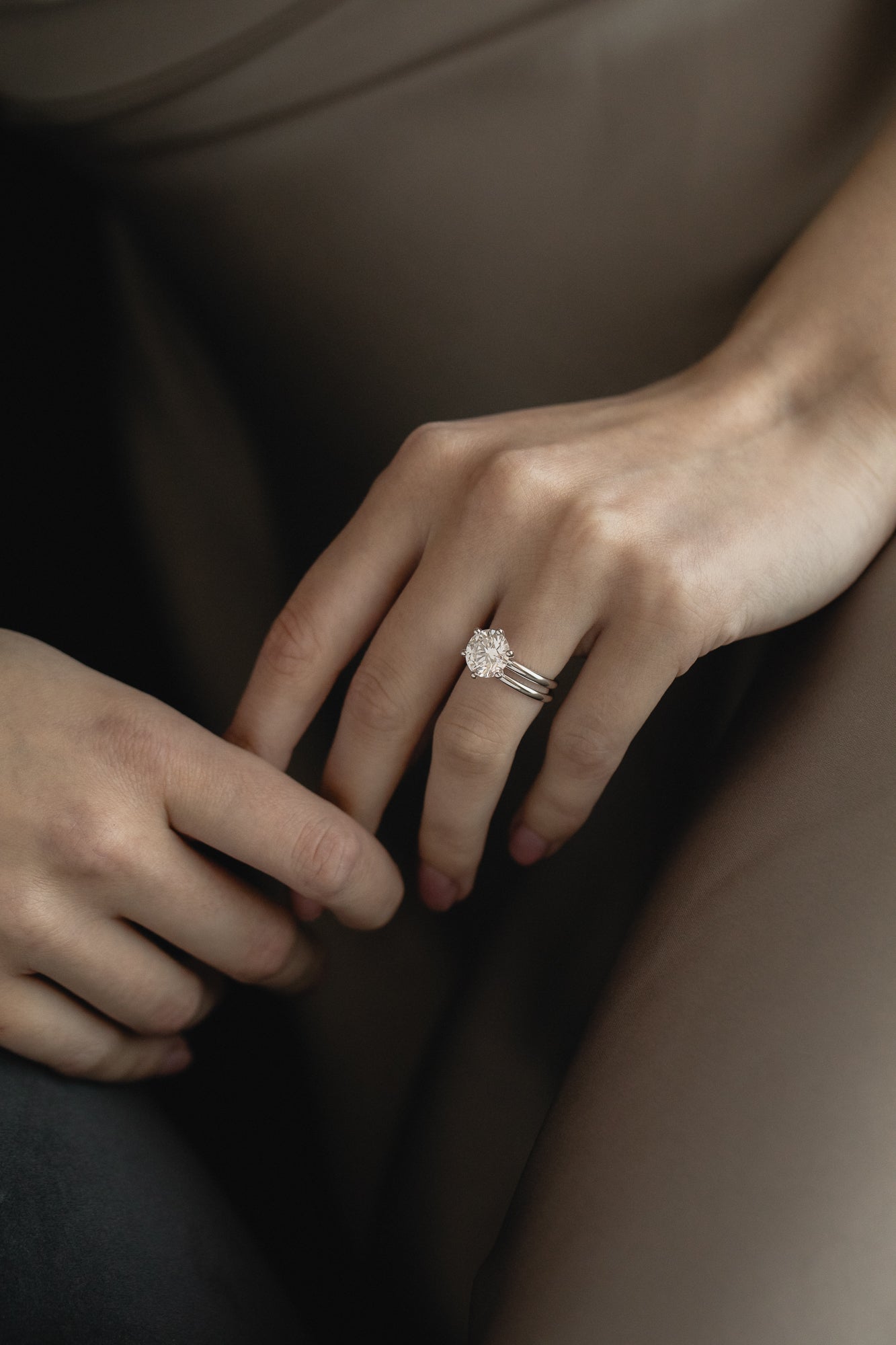 Close-up view of the KARAAT Round Six Prong Solitaire in 18k white gold on a model’s hand, showing the secure setting.