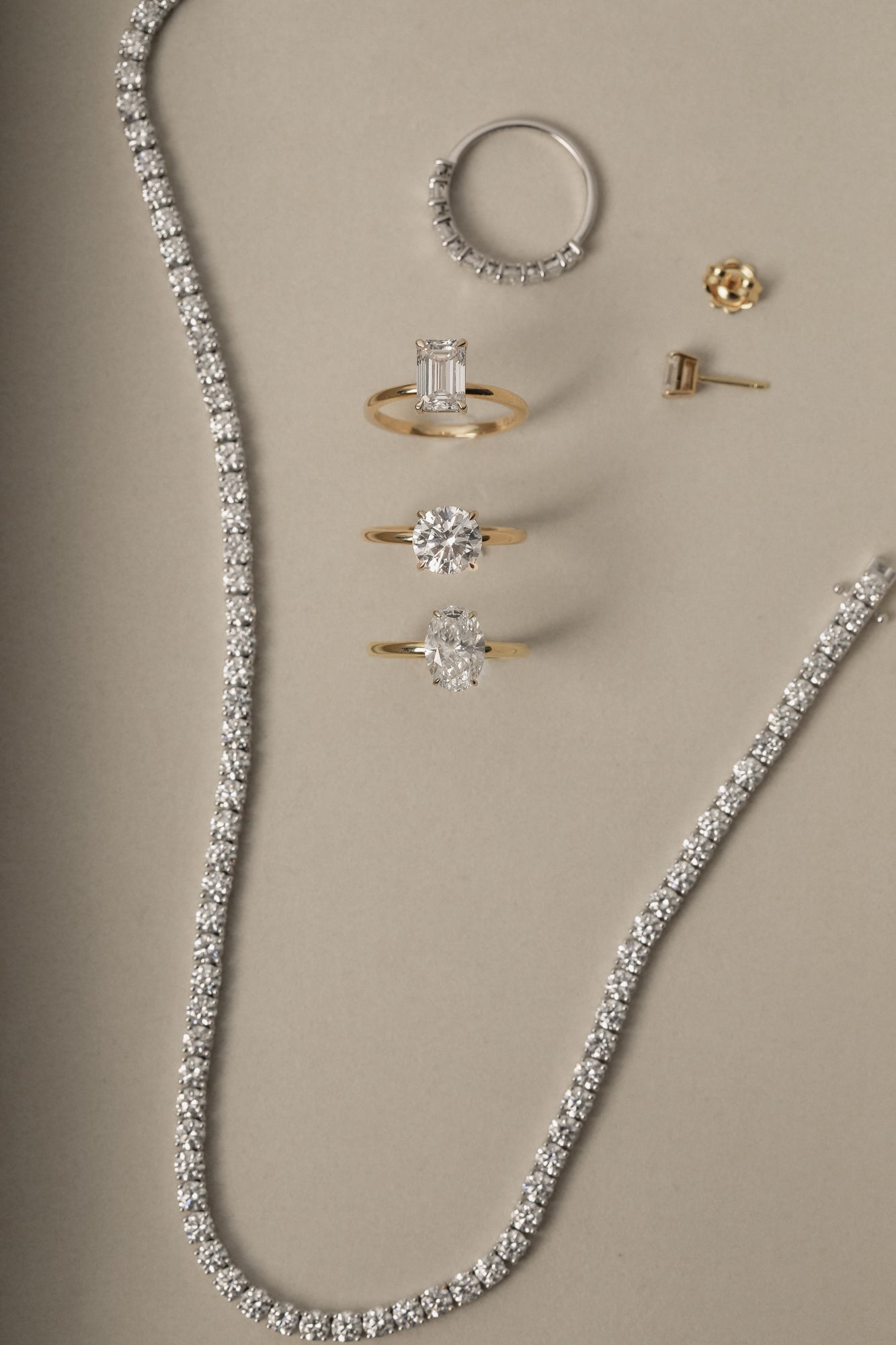 A KARAAT Round Solitaire engagement ring in 18k white gold, surrounded by complementing lab-grown diamond jewelry in a studio setting.