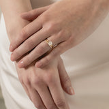 A model wearing a KARAAT Round Solitaire paired with a matching 18k white gold wedding band against a silk wedding dress.