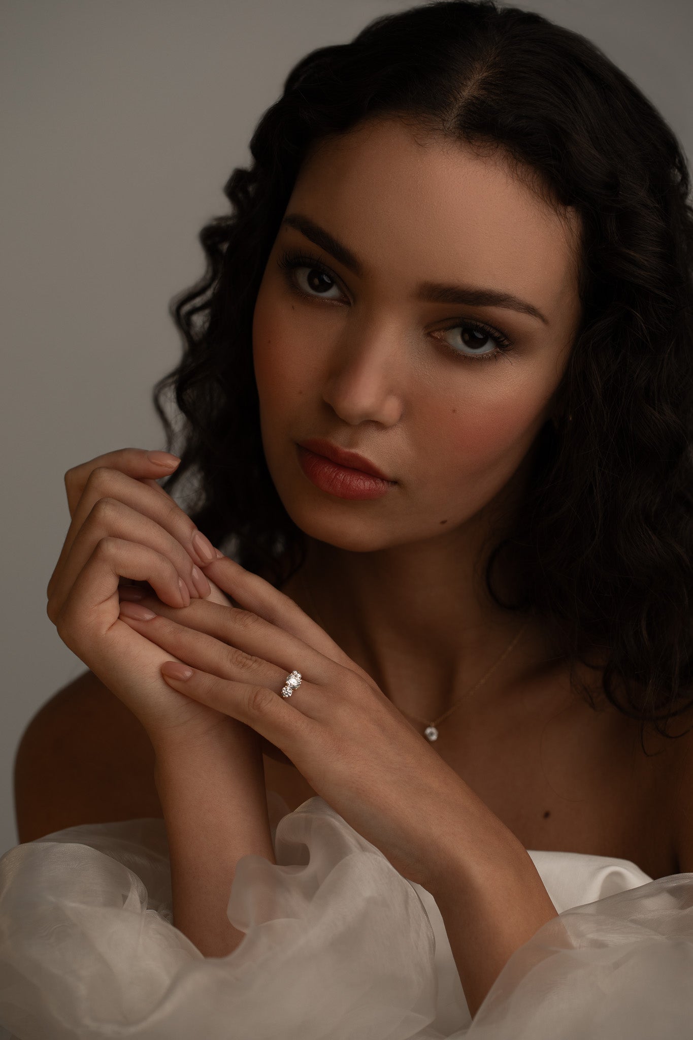 Romantic bridal styling with the KARAAT Round Trilogy three-stone diamond ring in 18k rose gold.