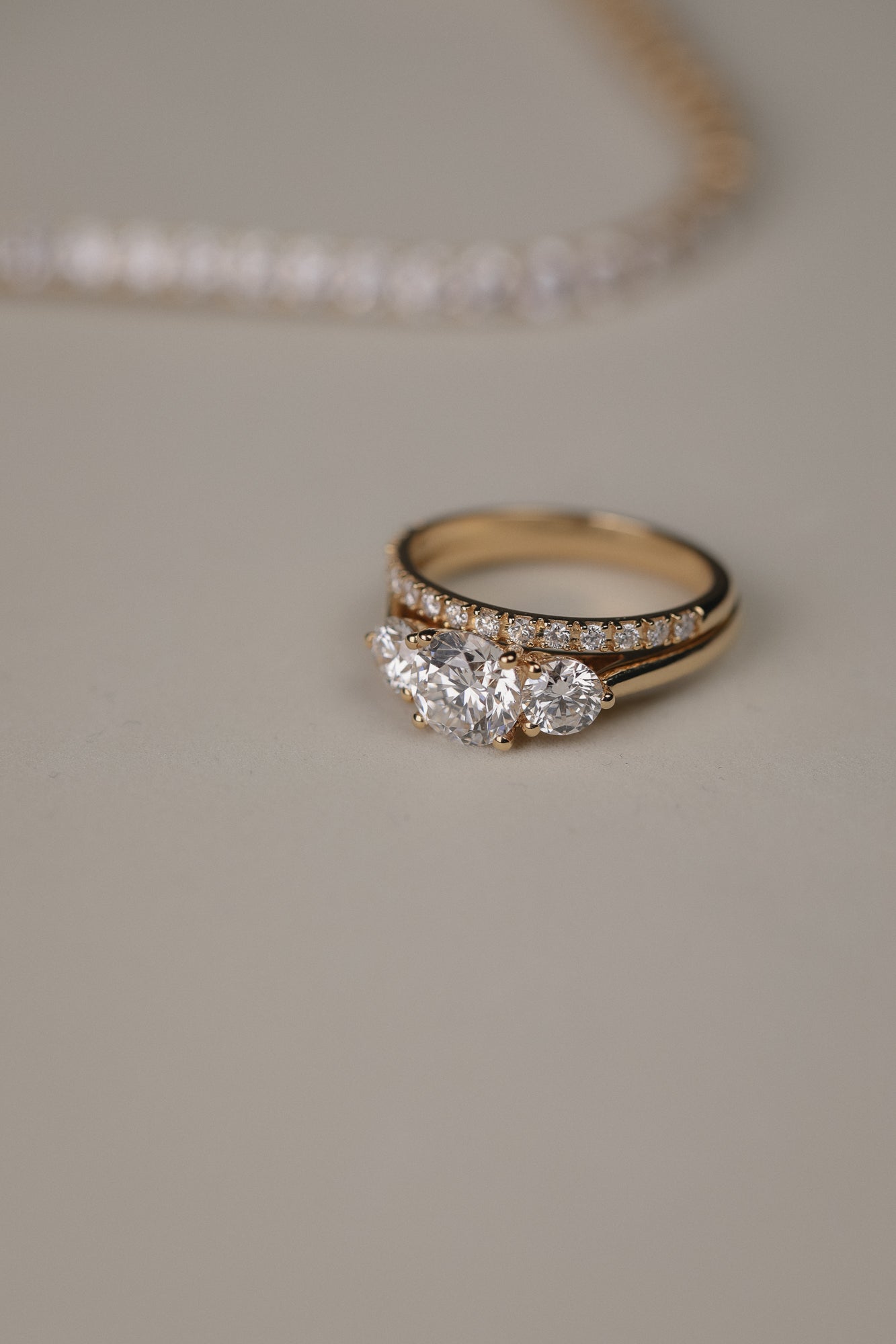Detailed close-up of the KARAAT Round Trilogy diamond ring in 18k white gold, showing the three-stone setting.