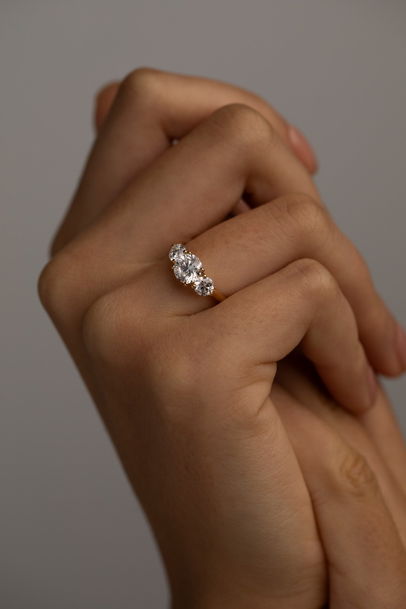 The KARAAT Round Trilogy engagement ring in 18k white gold shown on a model, highlighting its brilliant sparkle.