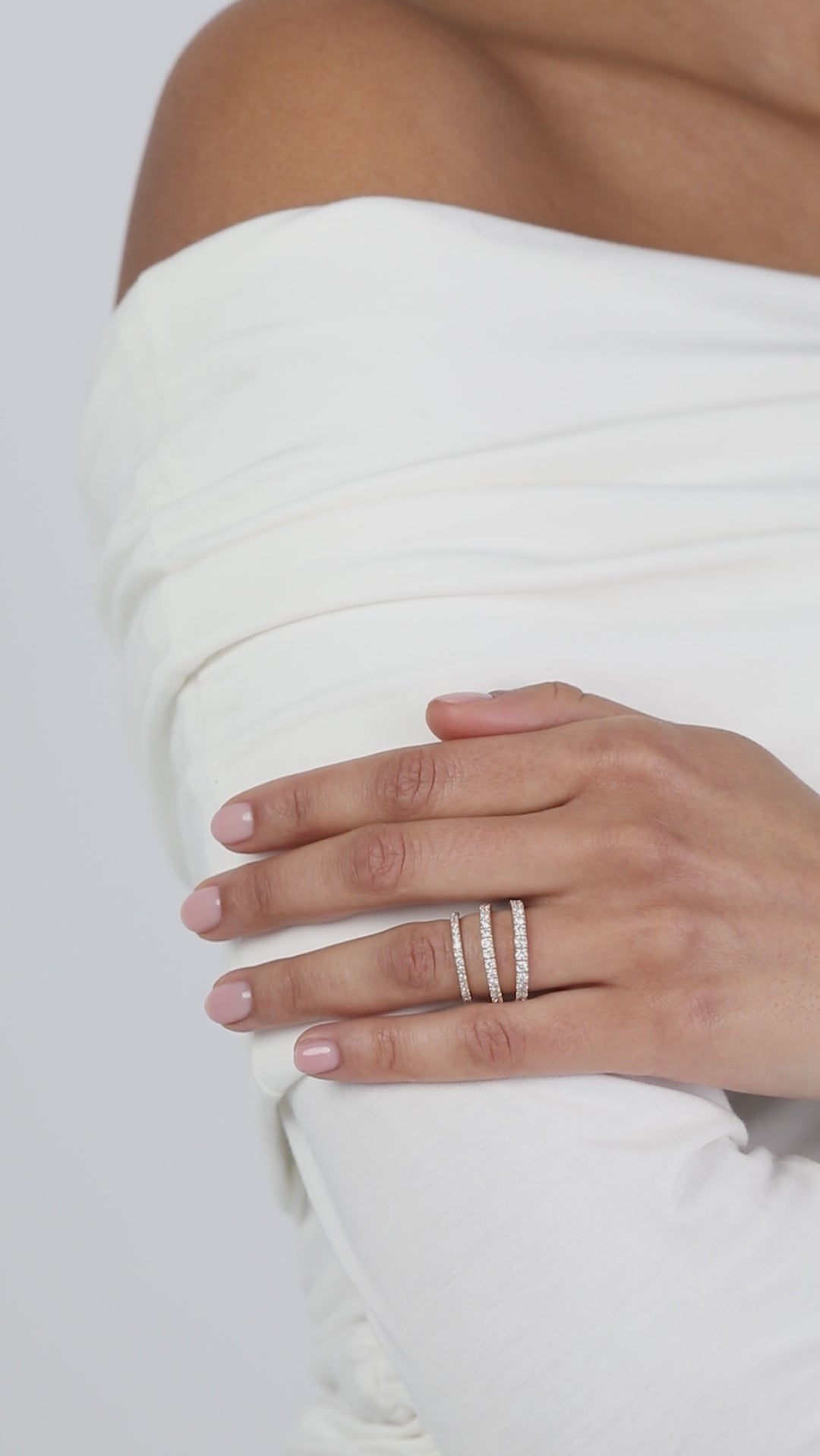 A video showcasing a modern, multi-layer ring stack featuring different widths of KARAAT yellow gold pavé diamond wedding bands on a model.