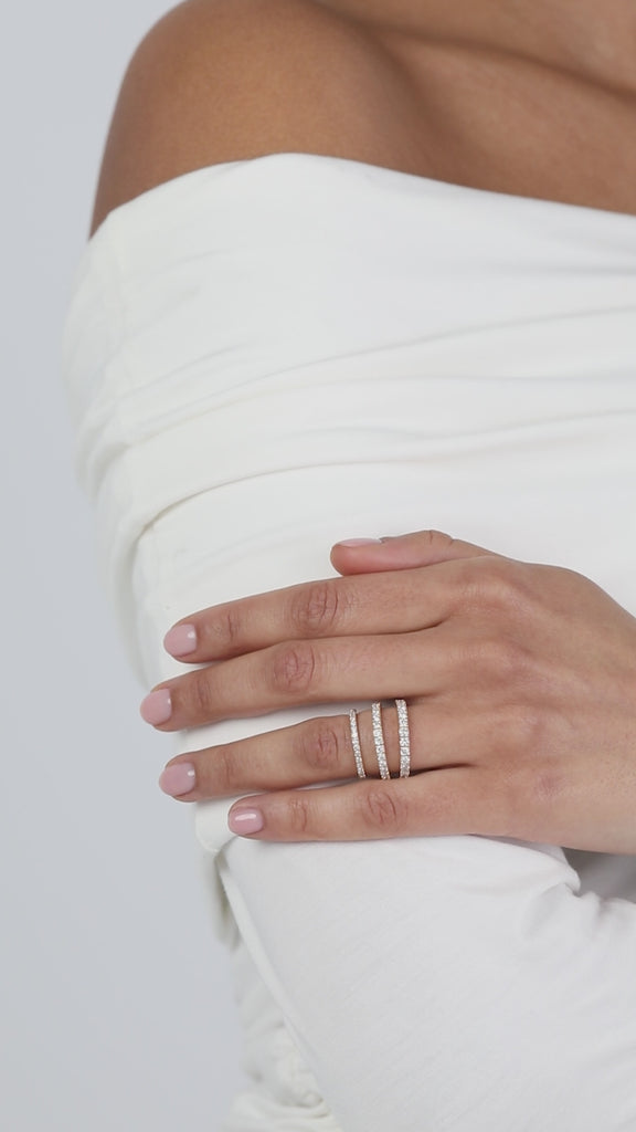A video showcasing a modern, multi-layer ring stack featuring different widths of KARAAT yellow gold pavé diamond wedding bands on a model.