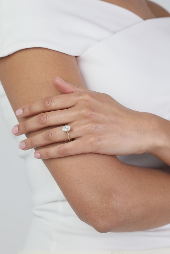 A model wearing a KARAAT lab-grown Oval Solitaire diamond ring in 18k white gold, showing the natural movement and sparkle of the pieces in a minimalist luxury setting.