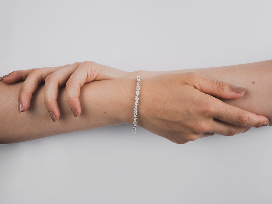 Elegant woman wearing luxurious Diamond Tennis Bracelet that is made of ethical lab-grown diamonds and 18k solid gold. 