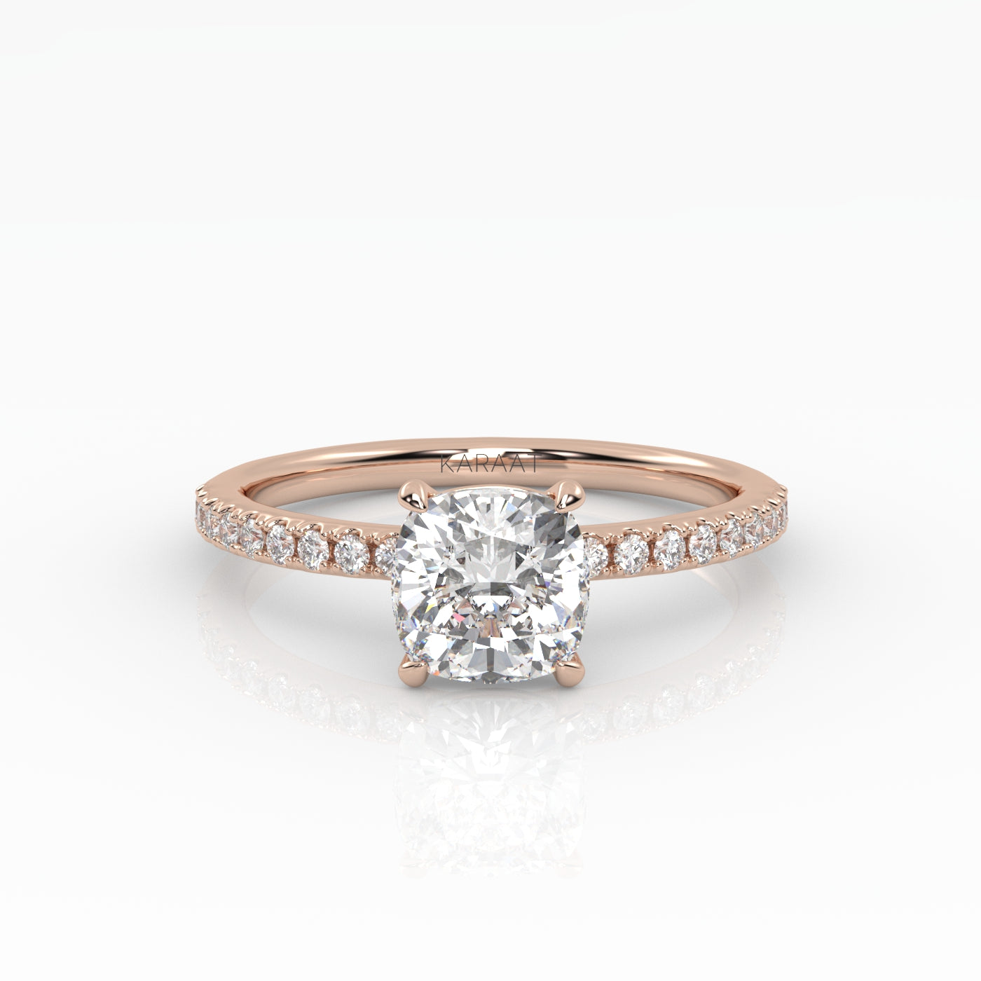 Classic cushion shaped solitaire diamond ring with a rose gold band featuring pavé diamonds. 