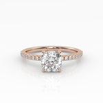Classic cushion shaped solitaire diamond ring with a rose gold band featuring pavé diamonds. 