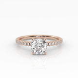 Classic cushion shaped solitaire diamond ring with a rose gold band featuring pavé diamonds. 